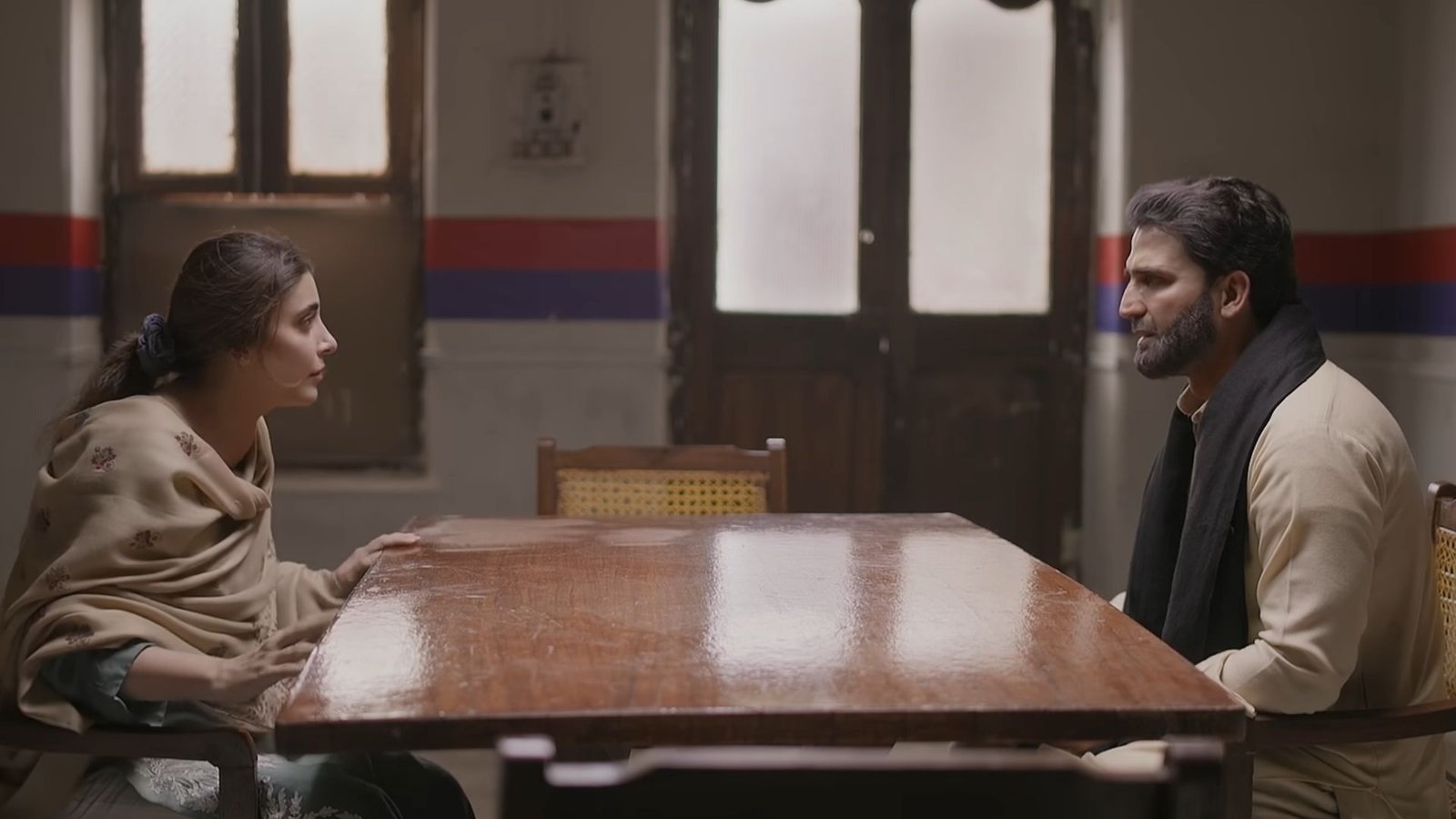 Beena and Hafiz seated opposite each other across a table